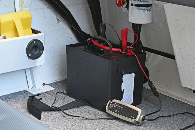 A battery is being charged in a boat with a charger.