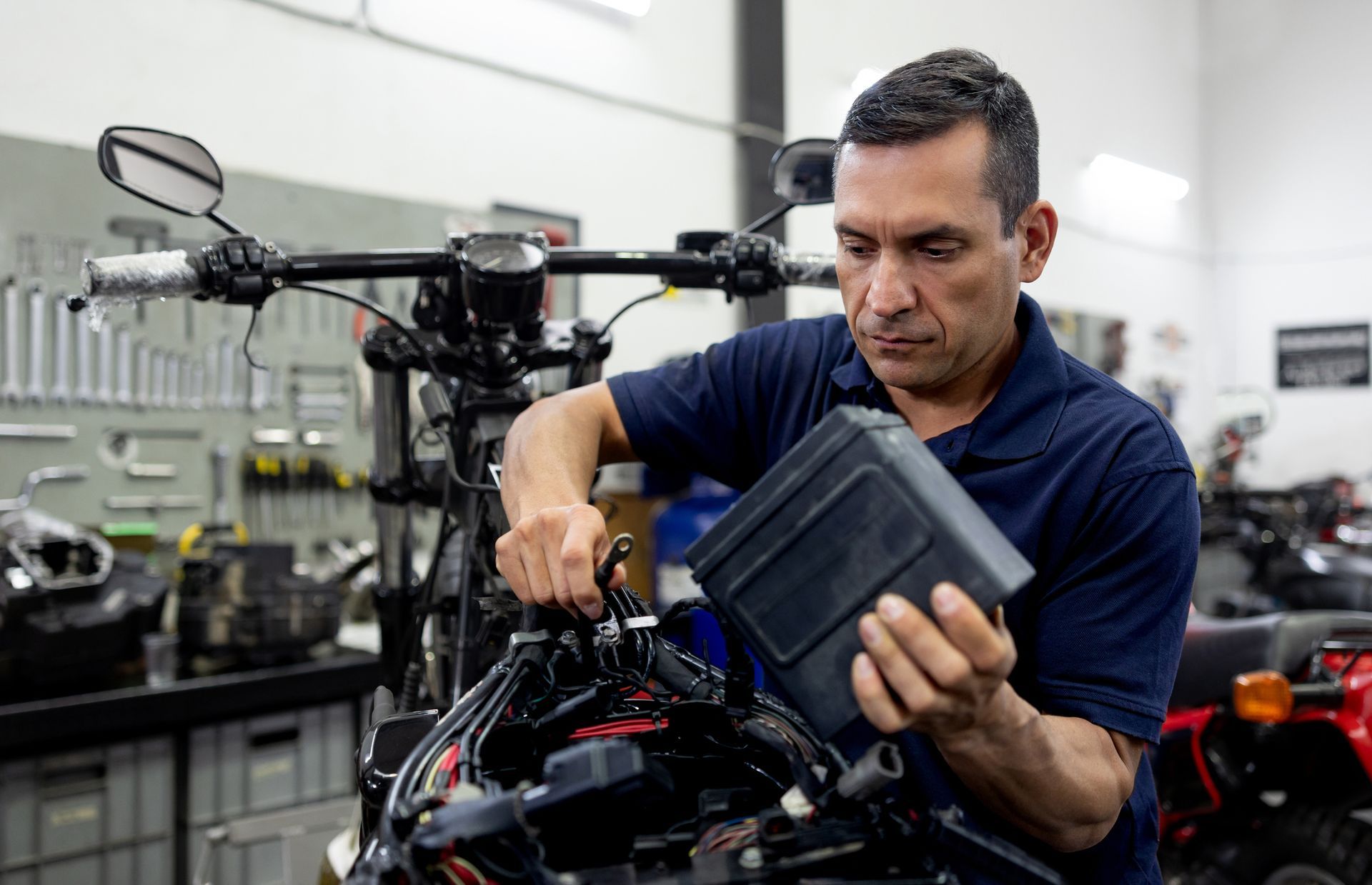 A man is working on a motorcycle in a garage.