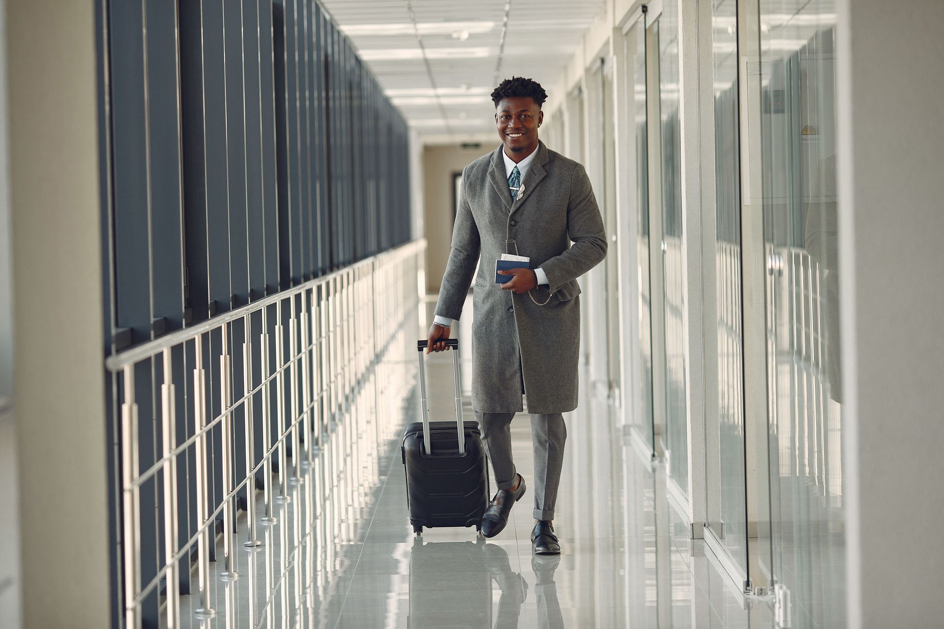 Business owner walking through an airport terminal with a suitcase on a work trip