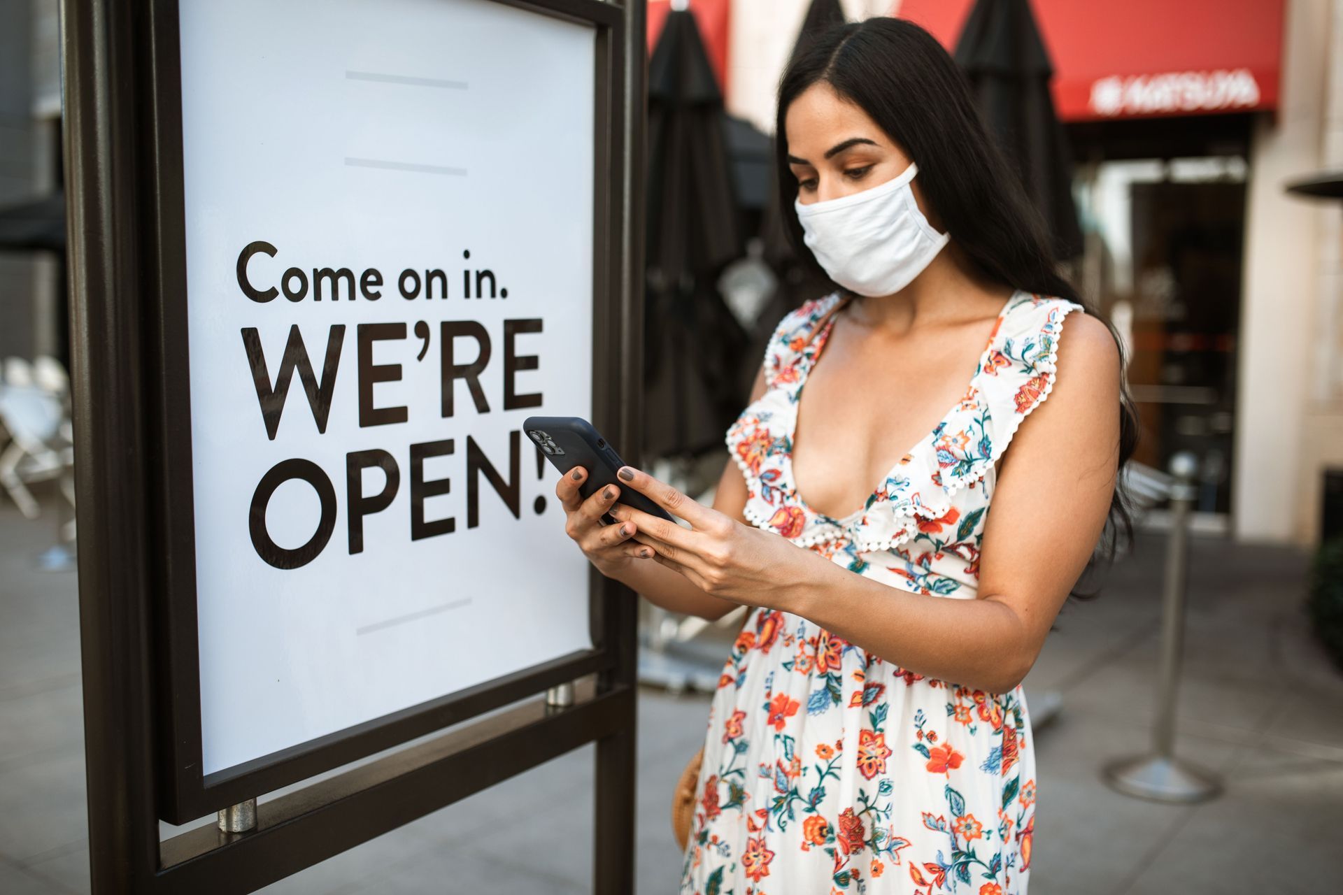 New shop owner standing outside her store under its open sign