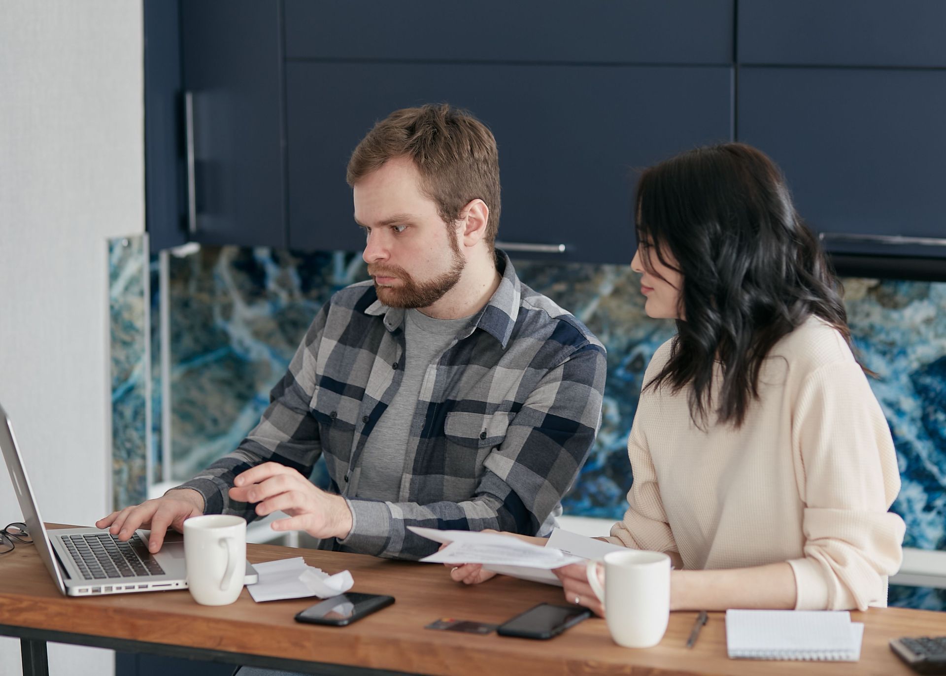 Business owner and contractor reviewing payroll tax paperwork at a table