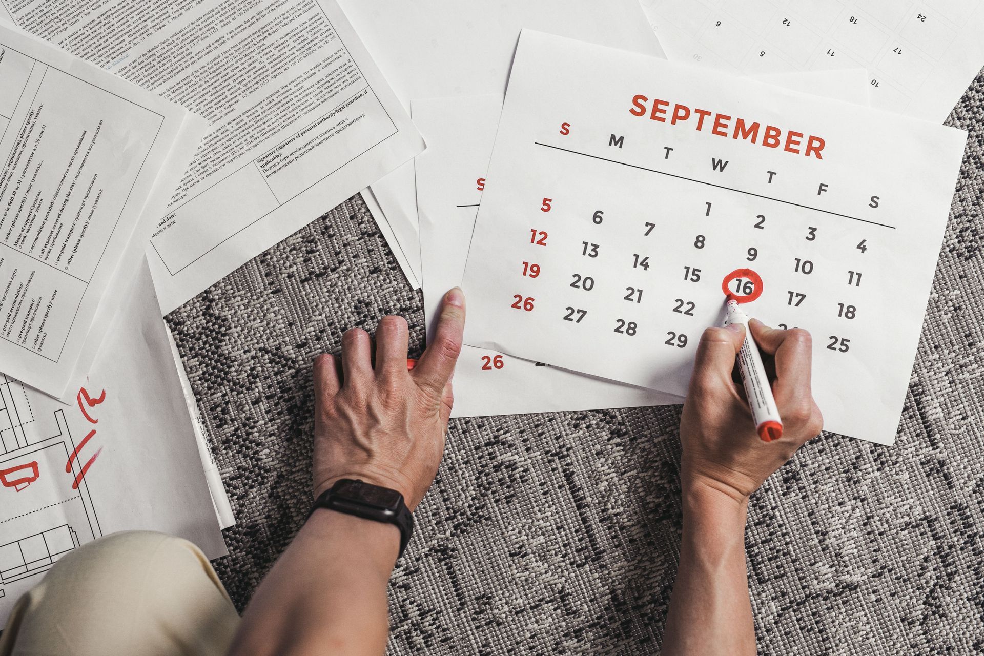 Employer marking staff annual leave dates on a desk calendar