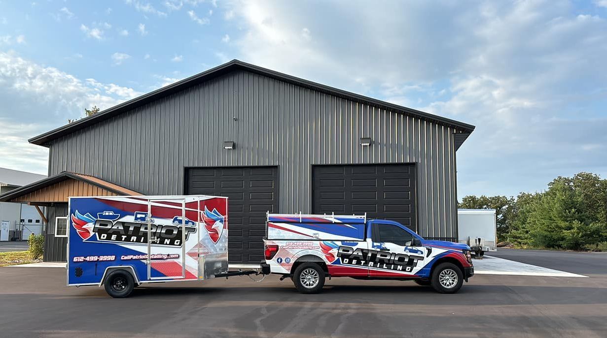 A truck and trailer are parked in front of a building.