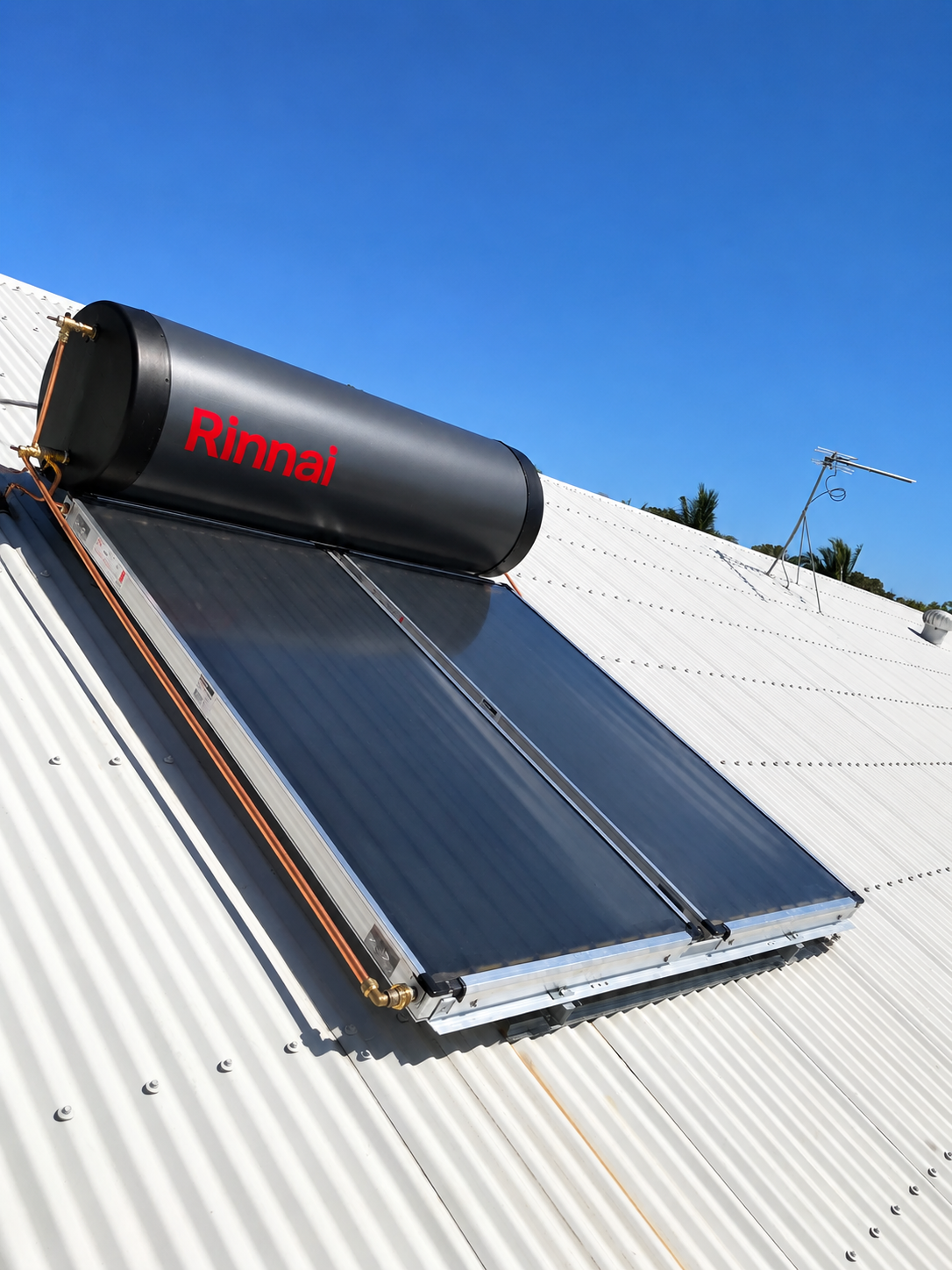 Solar water heater on a corrugated metal roof under a blue sky — Tap & Drain Doctor NT in Winnellie, NT