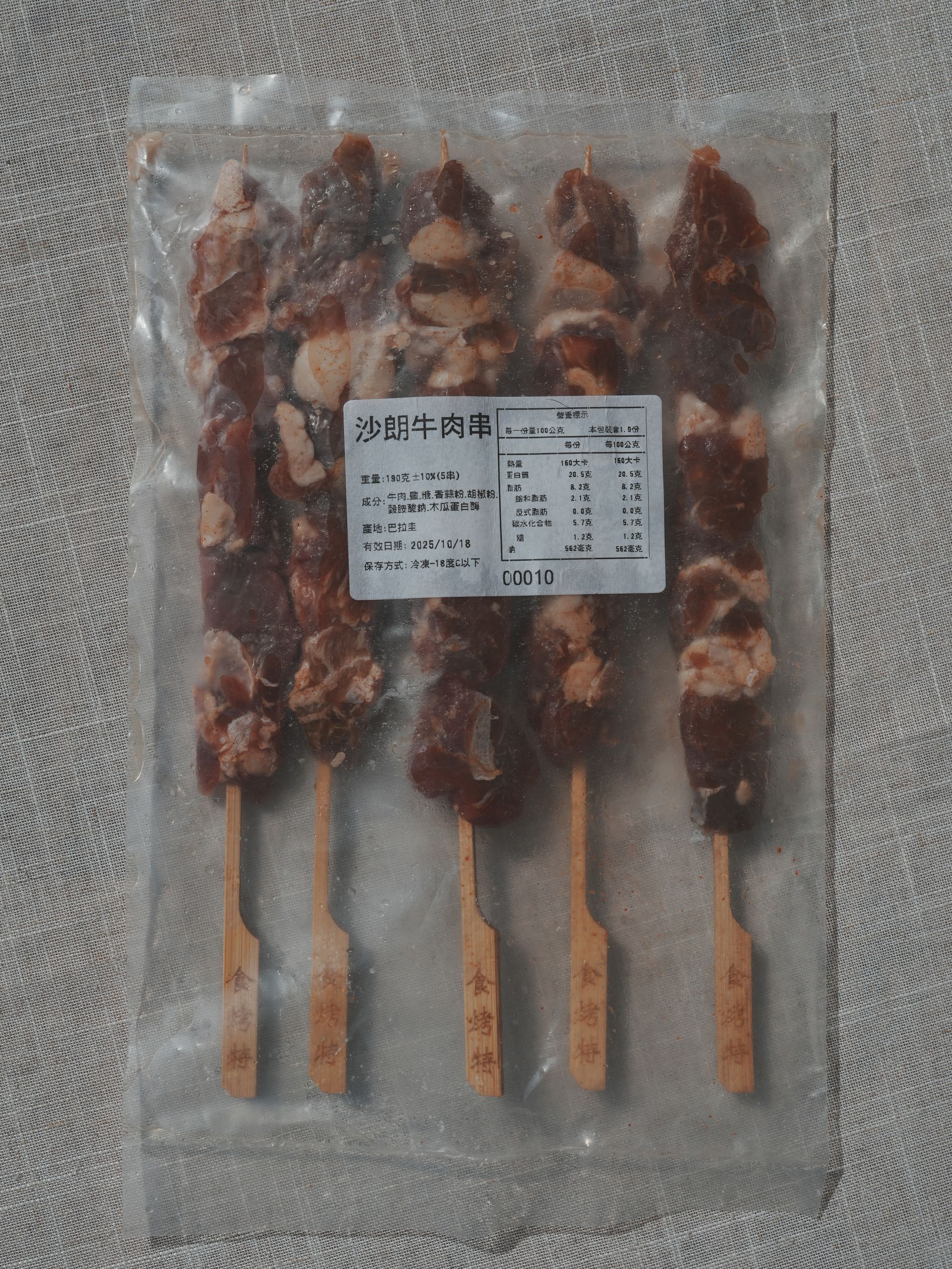 烤肉串，配上青檸和大蒜，放在木製砧板上。