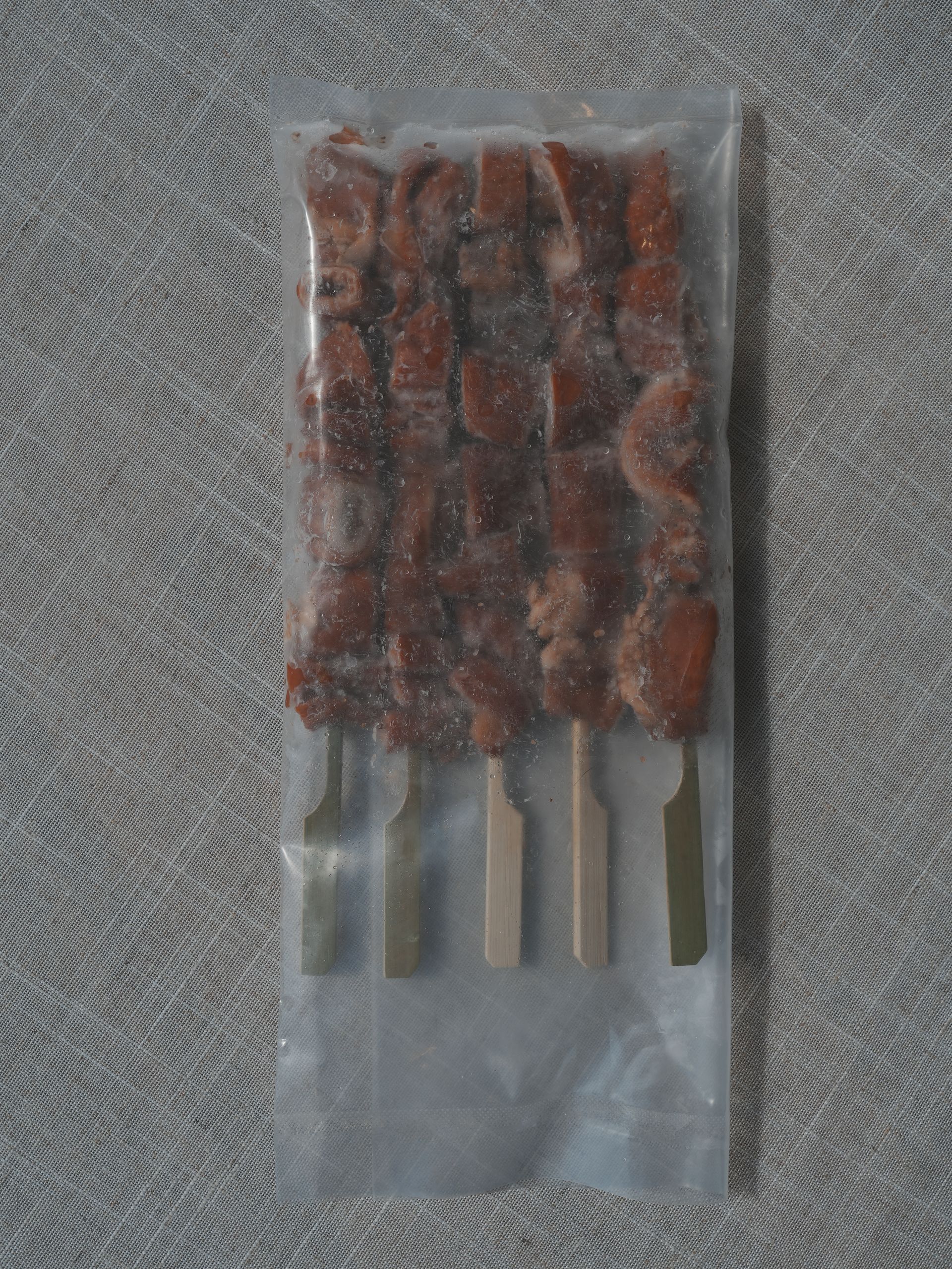 木板上烤著迷迭香肉串。
