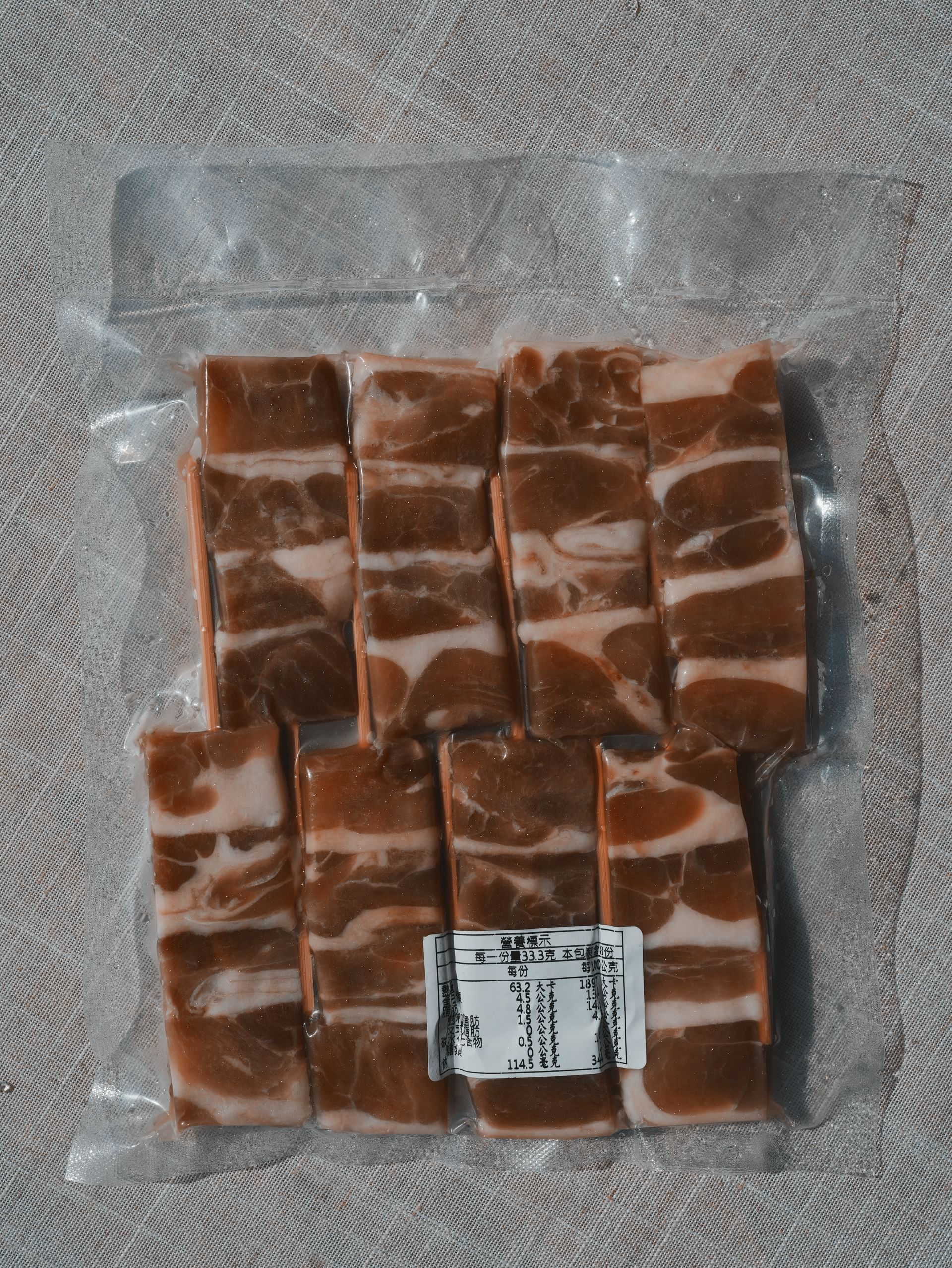 木板上擺放著培根串，點綴著白色花朵，沐浴在陽光下。
