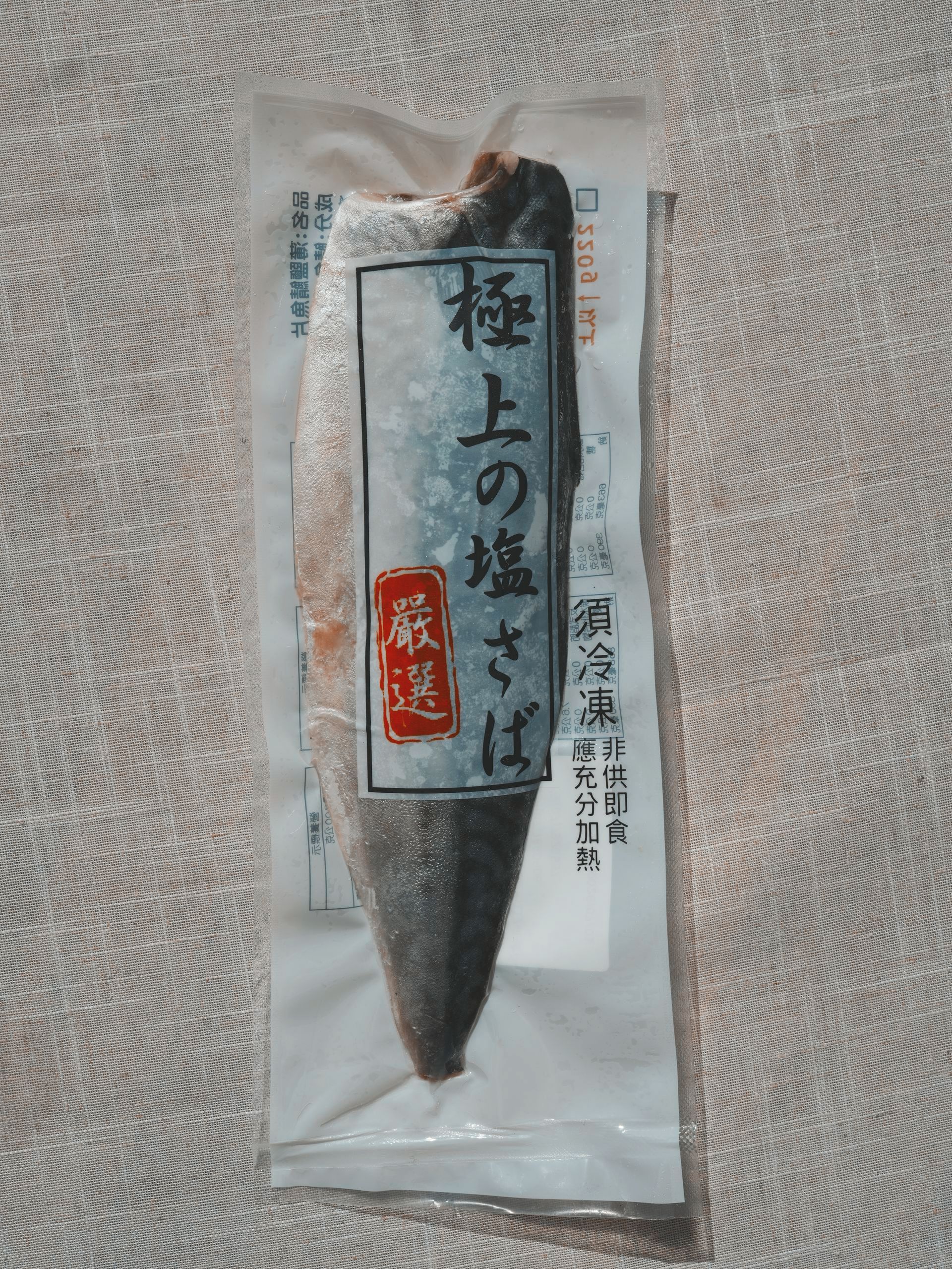 木板上放著鯖魚片，旁邊配上切碎的蔬菜。