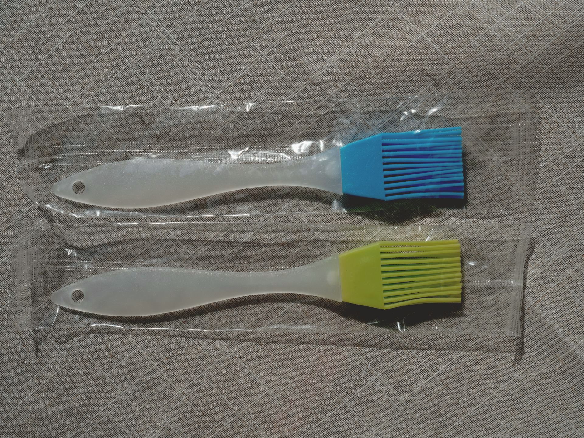 兩支矽膠塗油刷，藍色和綠色，透明塑膠包裝。