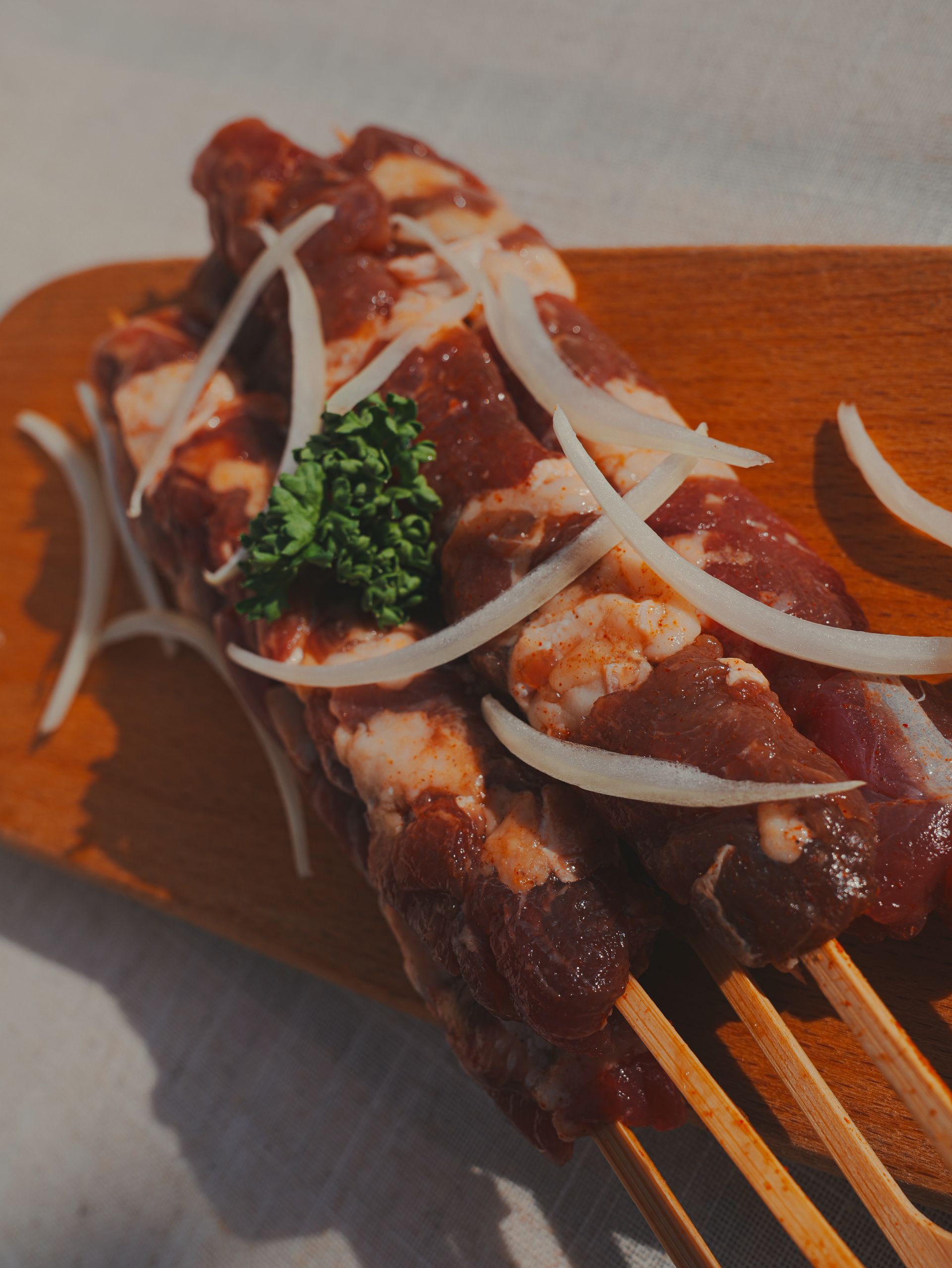 木板上串著生肉和洋蔥。