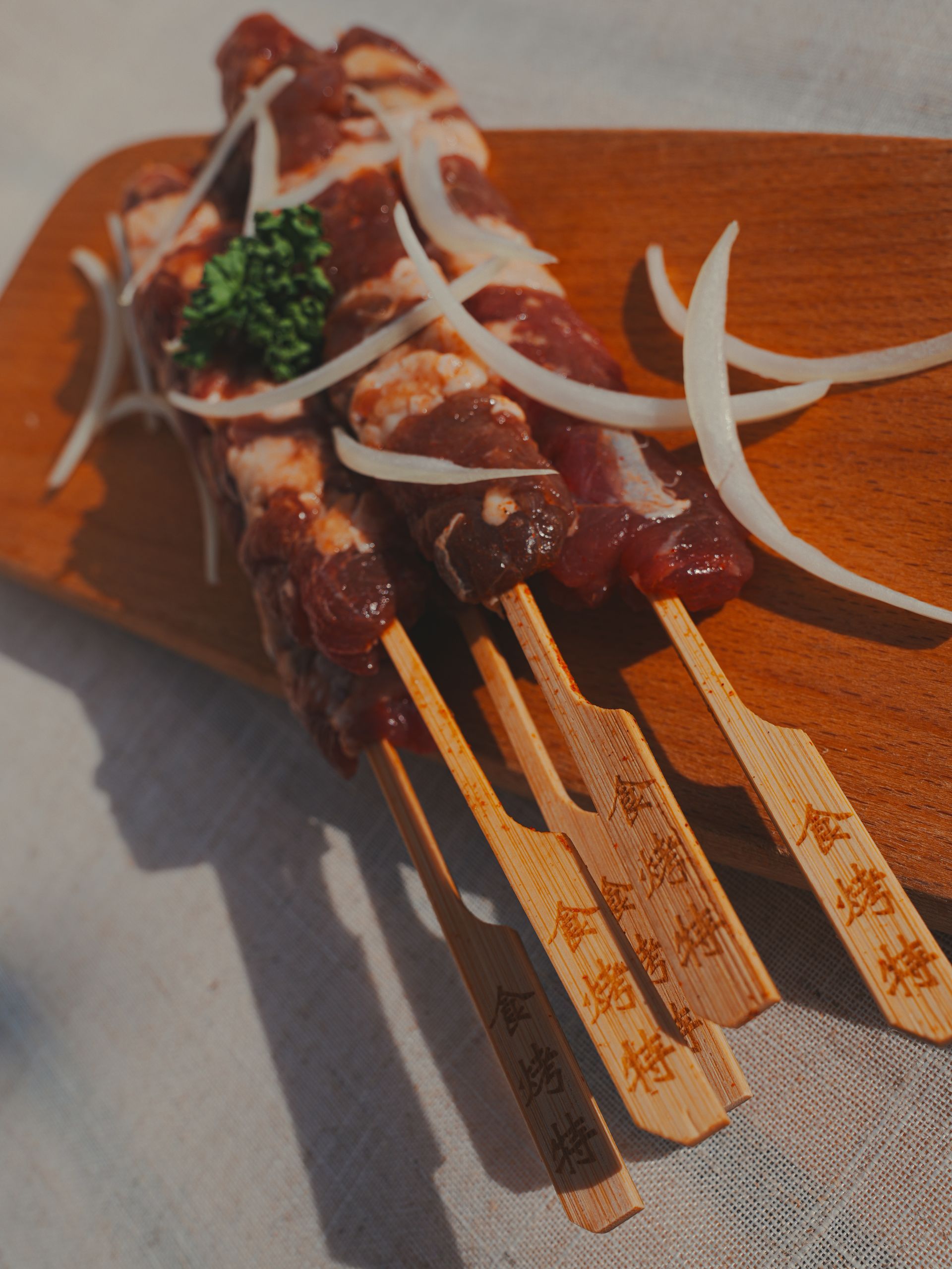 木板上串著生肉和洋蔥。