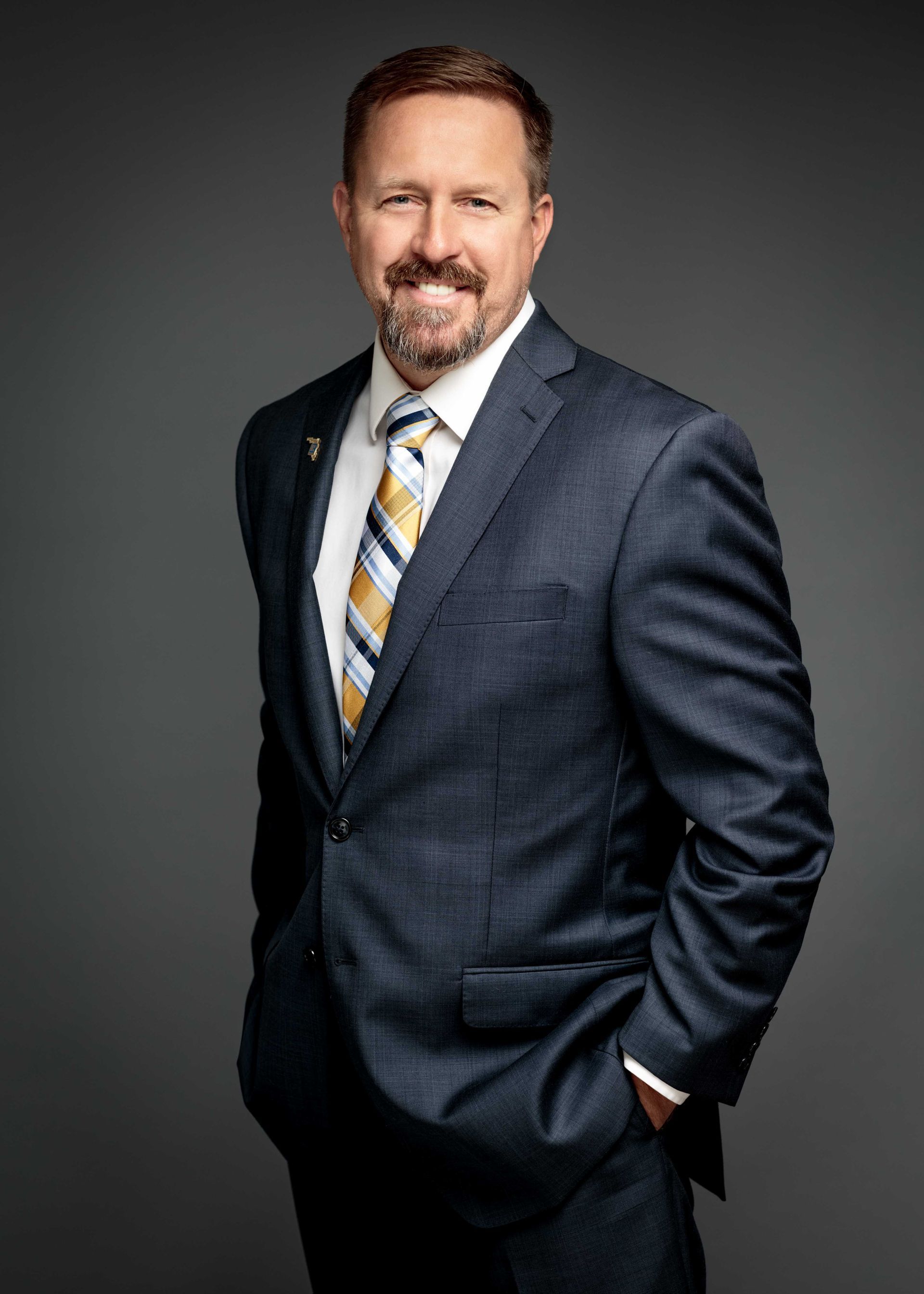 David Puskaric in a suit standing with hands in pockets