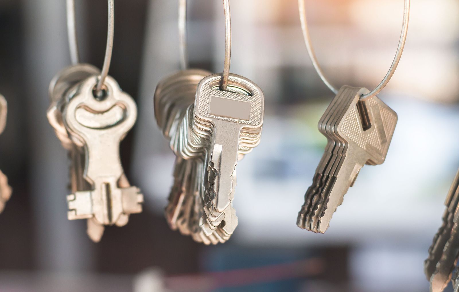 Keys hanging on wire, close-up, shiny metal, various shapes and sizes, locksmith display.