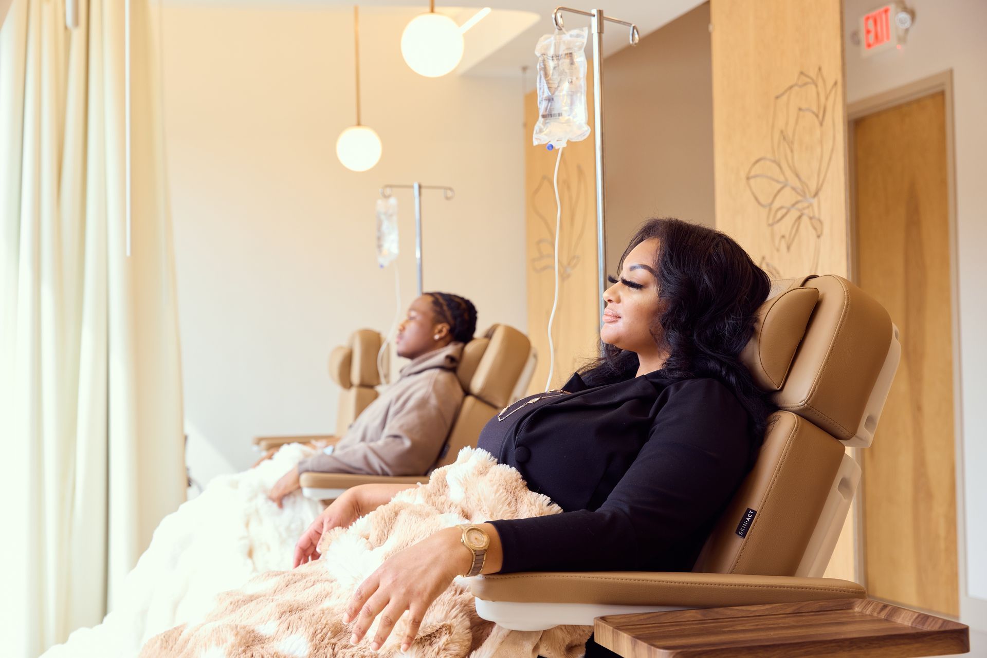 A woman in a bathrobe is sitting in a lounge chair at a spa.