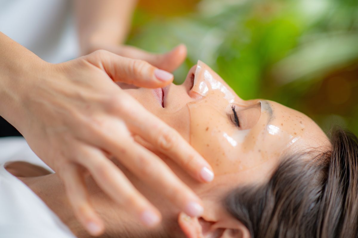 Person receiving a facial massage with cream in a spa setting