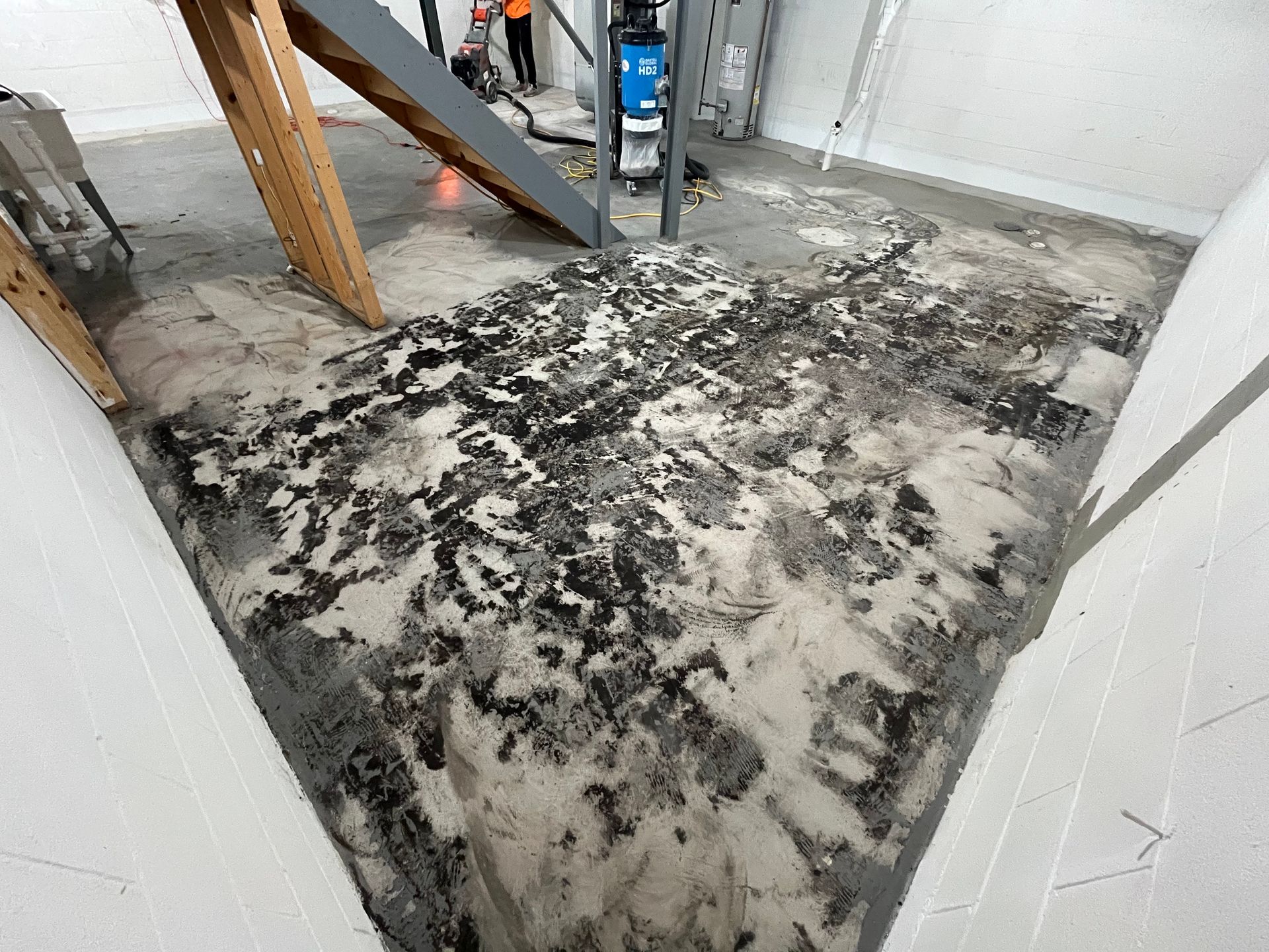 A dirty floor with a staircase in the background.