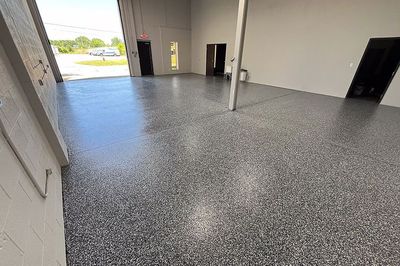 A large room with a gray floor and a white wall.