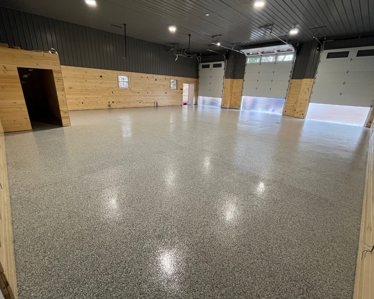 A large empty garage with a concrete floor and a garage door.