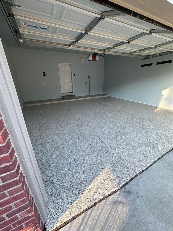 A garage with a concrete floor and a brick wall.