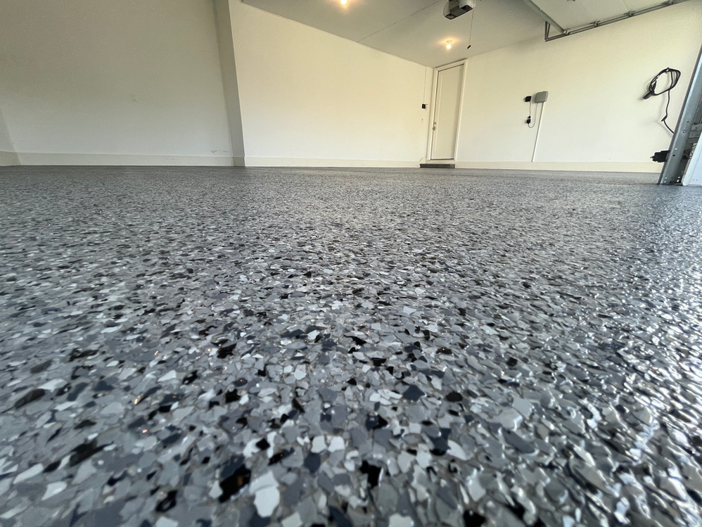 A garage with a gray and black floor and white walls.