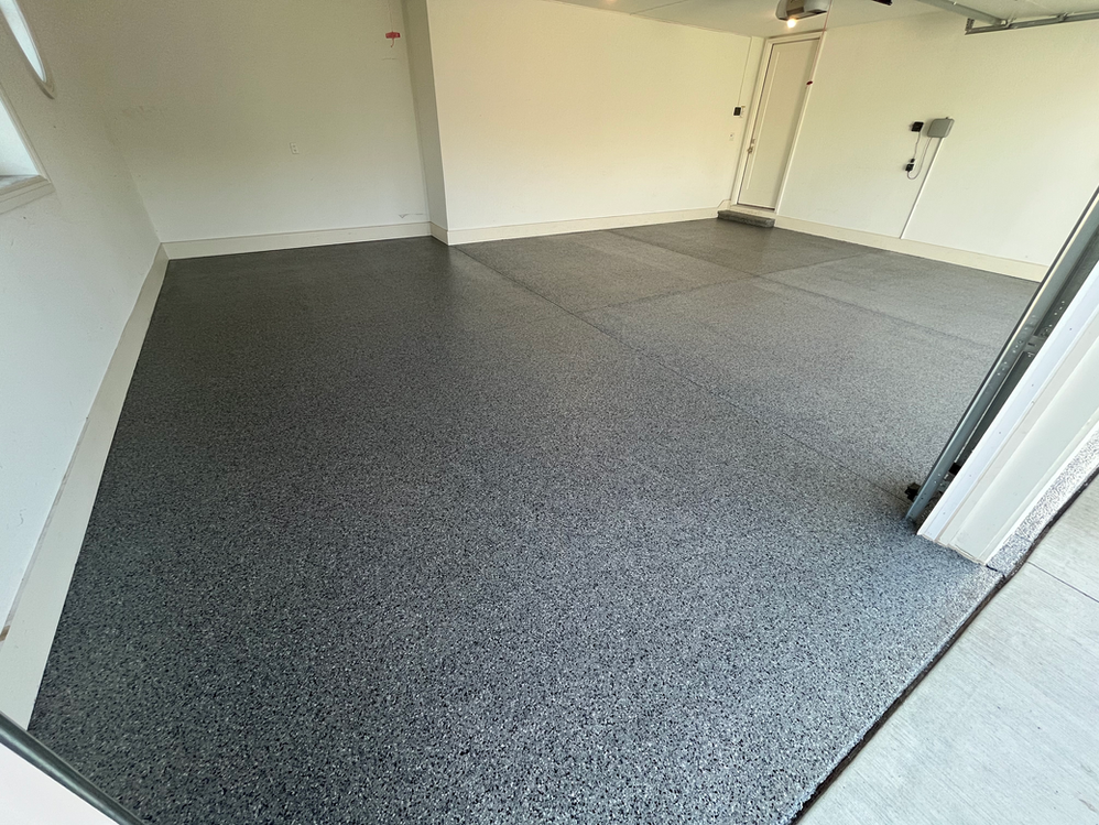 A garage with a gray floor and white walls.