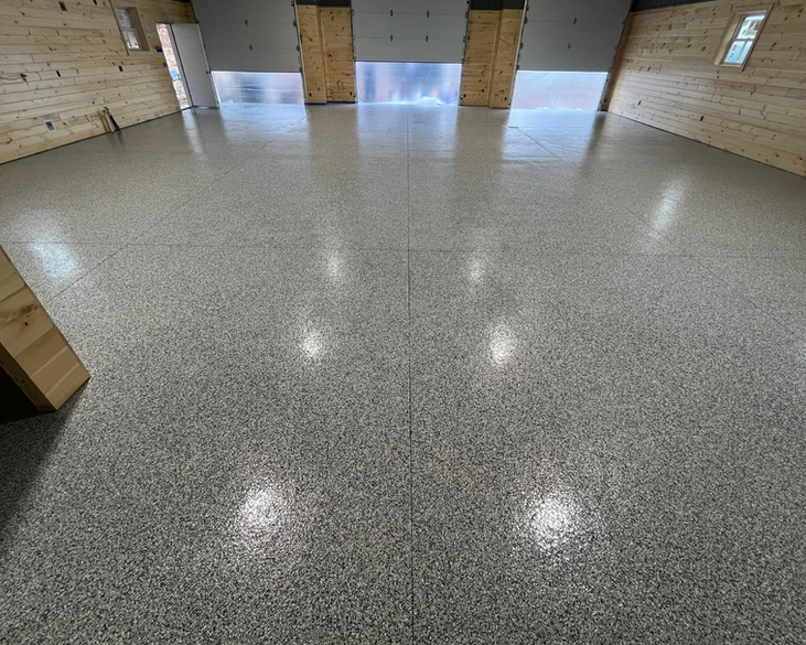 A garage with a shiny concrete floor and wooden walls.