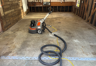 A machine is sitting in a garage with a hose attached to it.