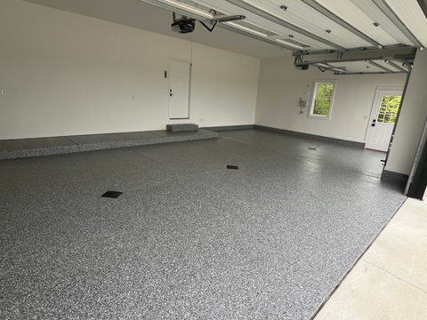 An empty garage with a gray floor and white walls.