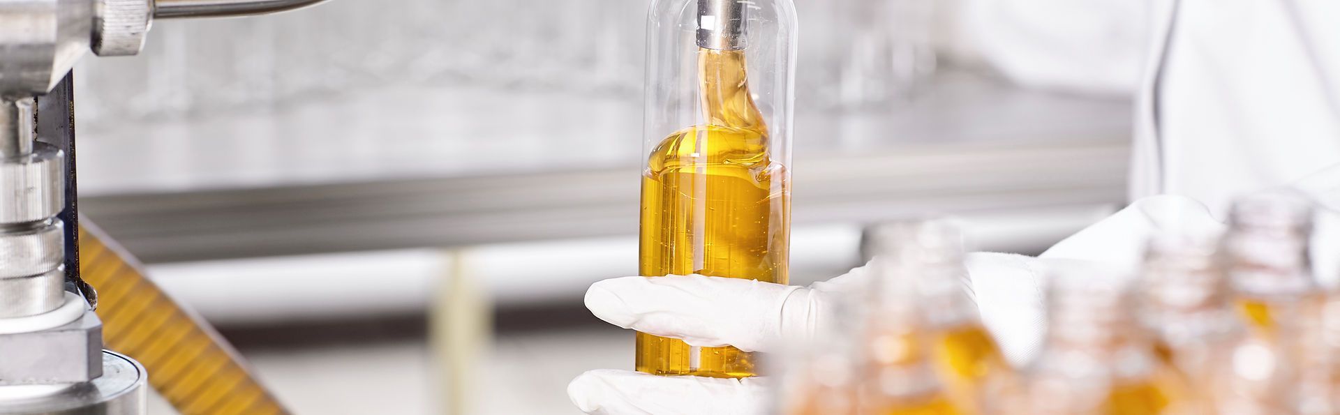 A person is filling a bottle of liquid with a machine.