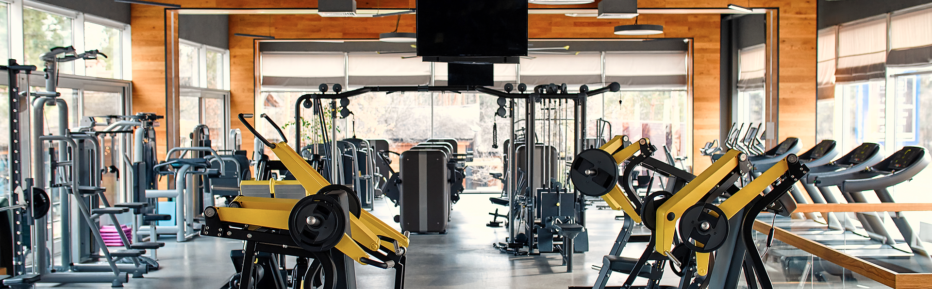 A large gym filled with lots of exercise equipment.