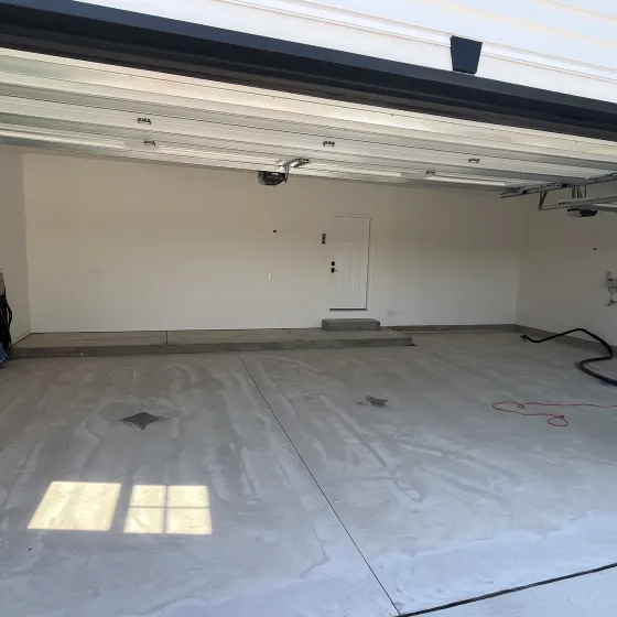 An empty garage with the door open and the lights on