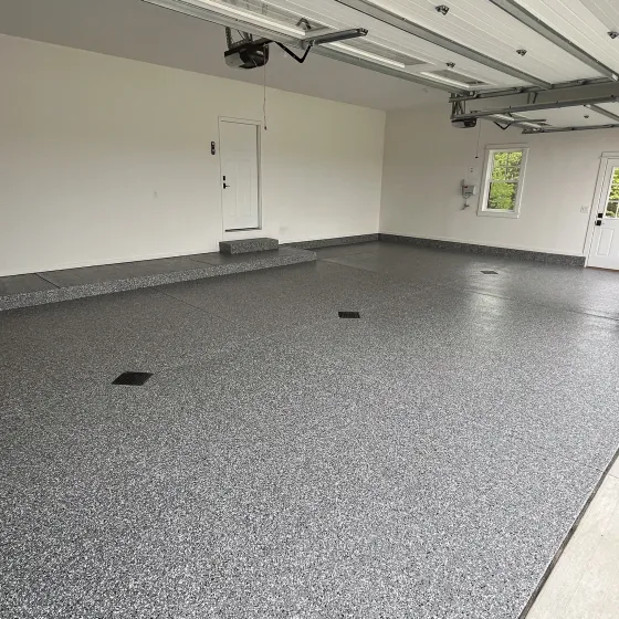 A large empty garage with a gray floor and white walls.