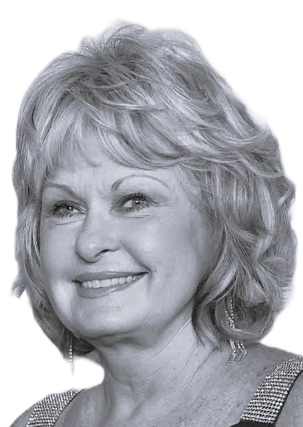 Black-and-white portrait of a smiling woman with short wavy hair, wearing a sequined top