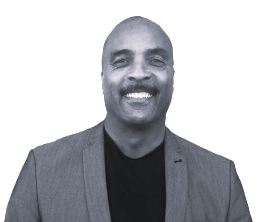 Smiling man in a gray blazer and black shirt against a white background