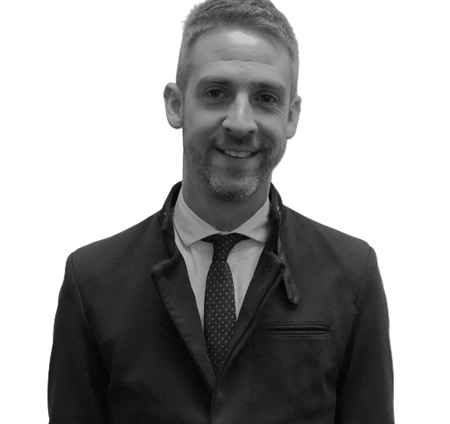 Smiling man in a dark suit and tie against a plain white background