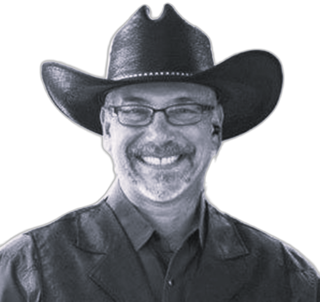 Smiling man in a black cowboy hat and glasses, wearing a dark shirt