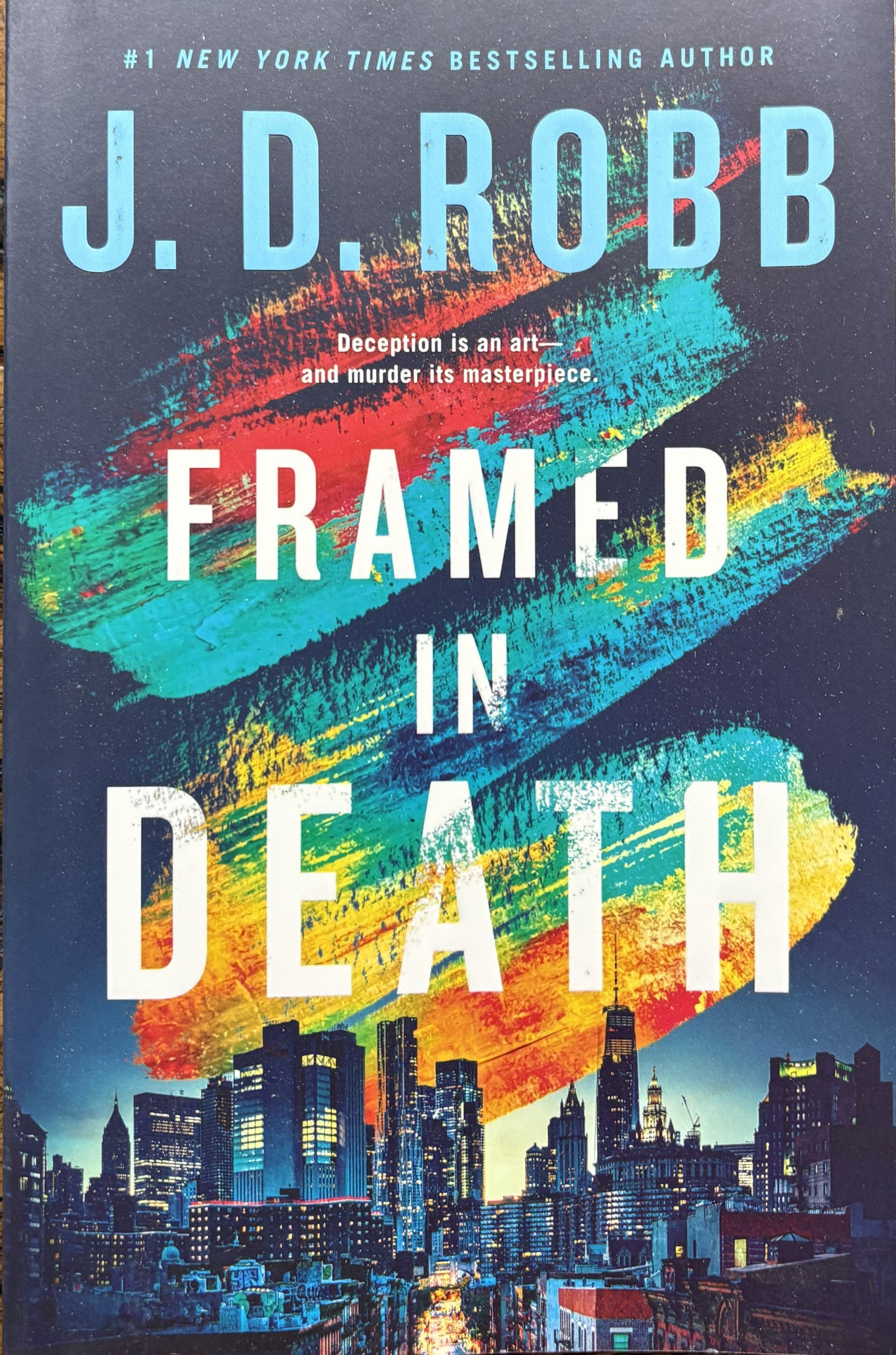 Book Title: "Framed in Death" by by J.D. Robb. Cover displays a skyline at bottom.