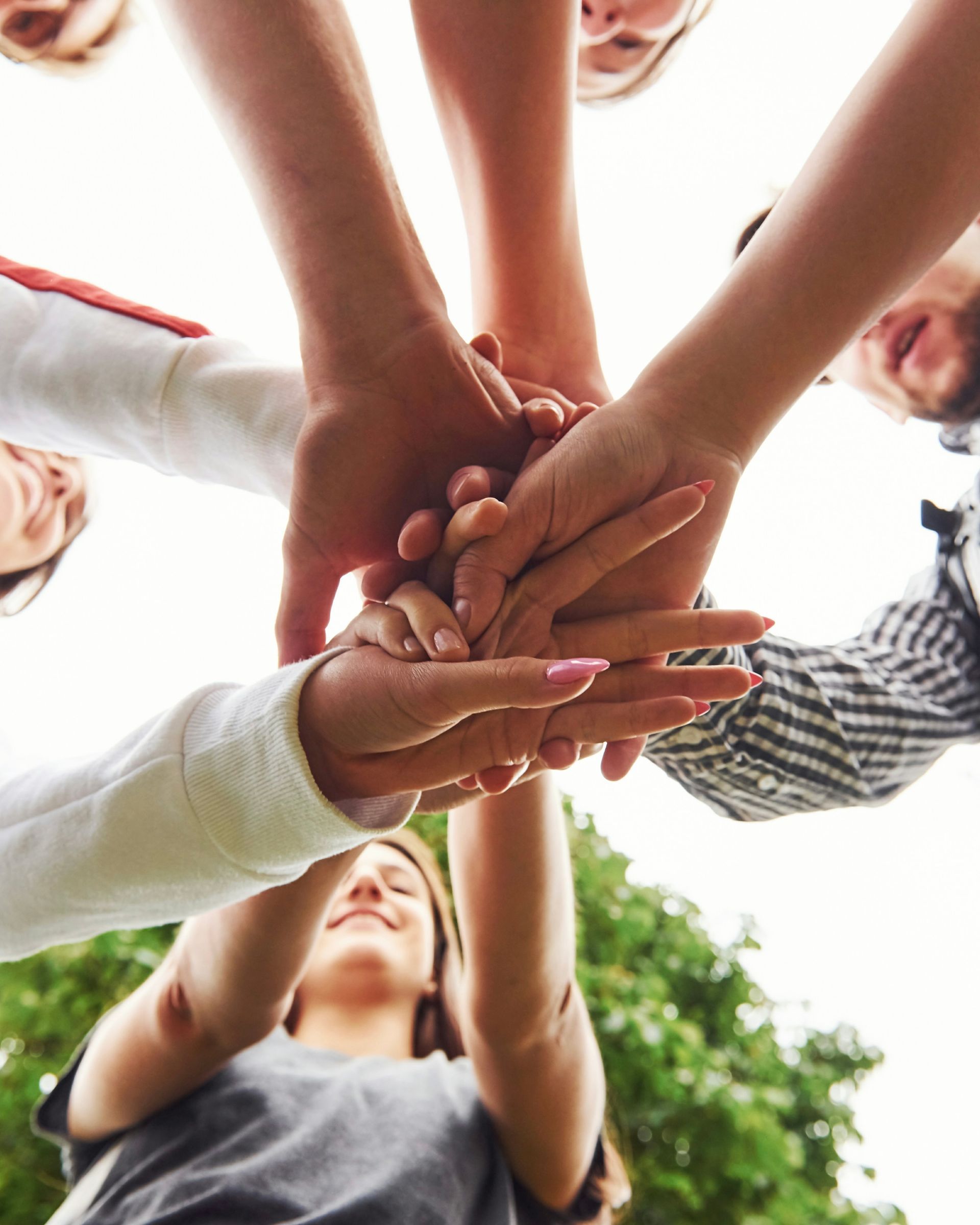 A group of people putting their hands together in a circle