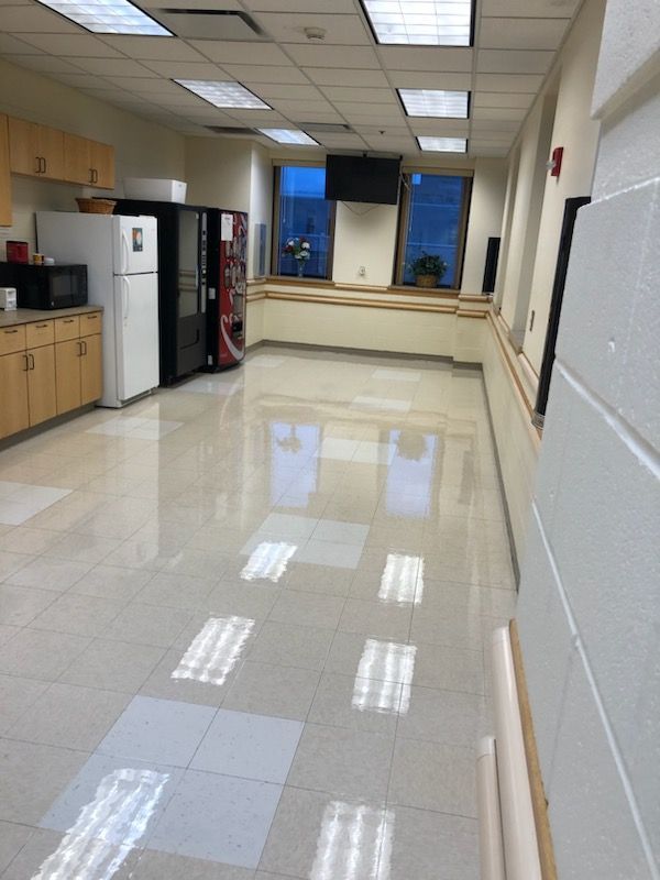 A long hallway with a vending machine and a refrigerator