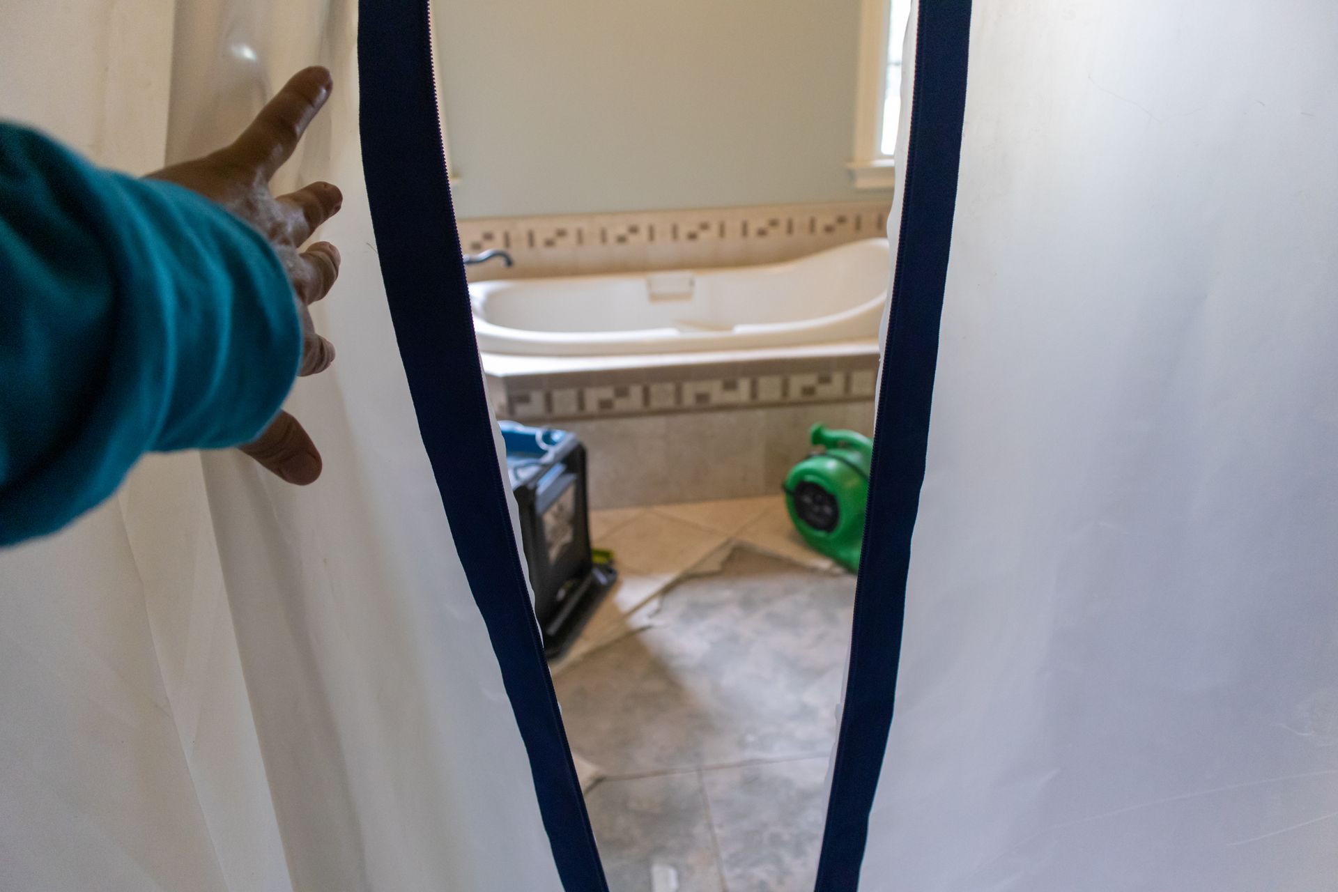 A person is looking through a shower curtain into a bathroom