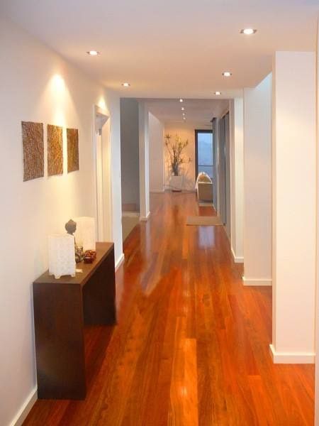 A Hallway With Hardwood Floors And White Walls  — Greg Keft Electrical in Port Macquarie, NSW