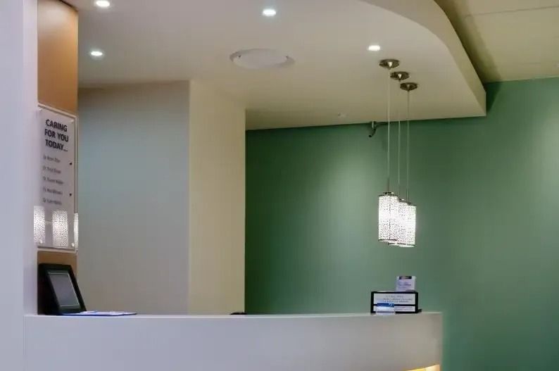 A Reception Area With A White Counter And Green Walls — Greg Keft Electrical in Port Macquarie, NSW