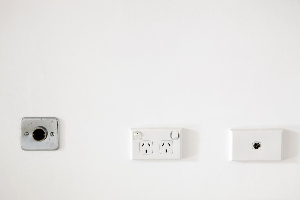 A White Wall With Three Electrical Outlets And A Light Switch  — Greg Keft Electrical in Port Macquarie, NSW