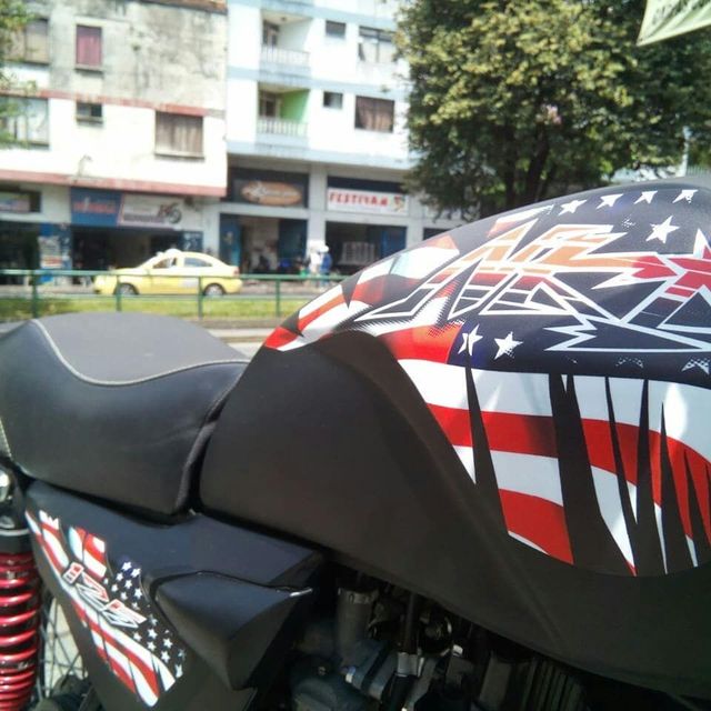 Motocicleta personalizada con gráficos de la bandera estadounidense aparcada en una calle de la ciudad