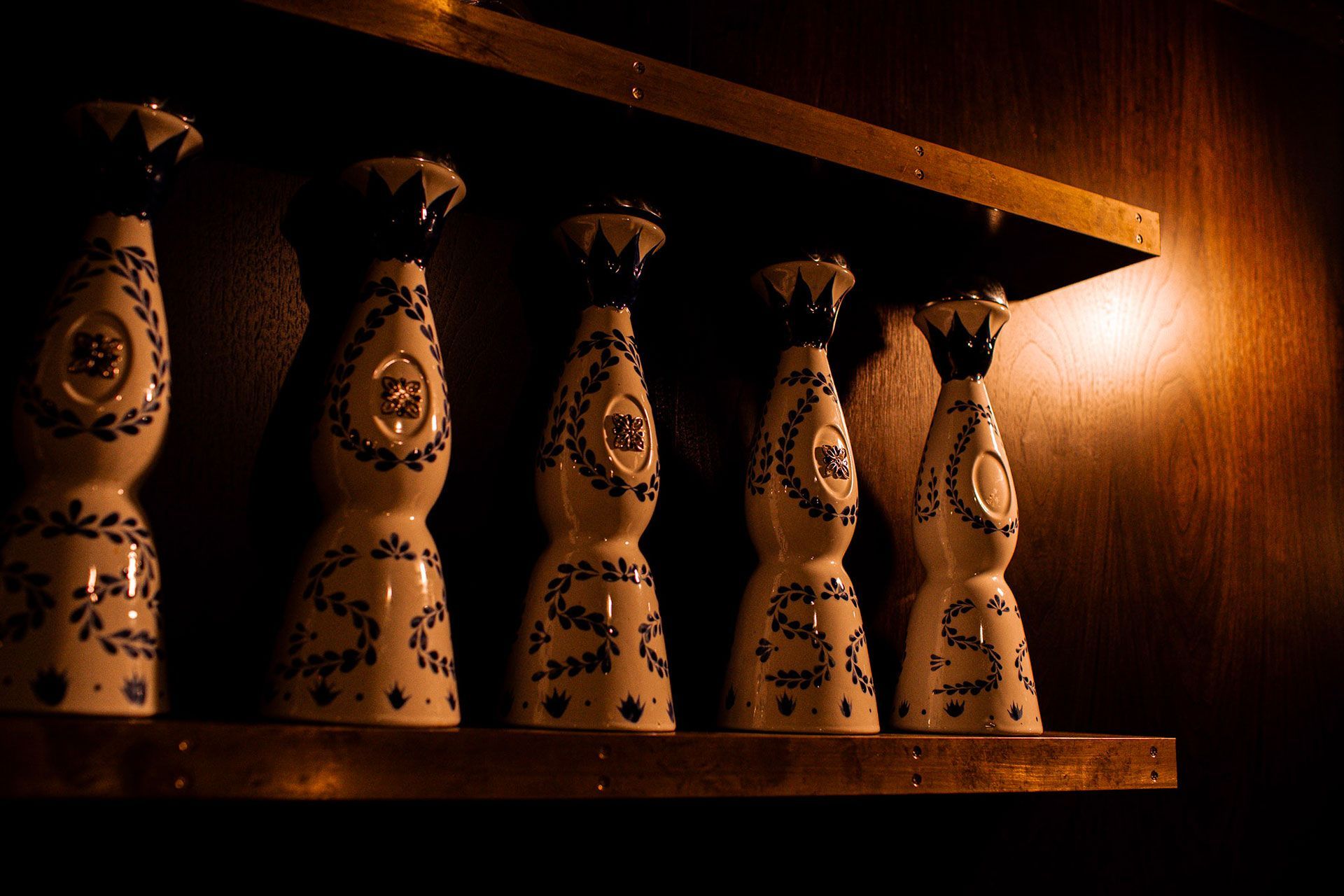  decorative bottles on a wooden shelf