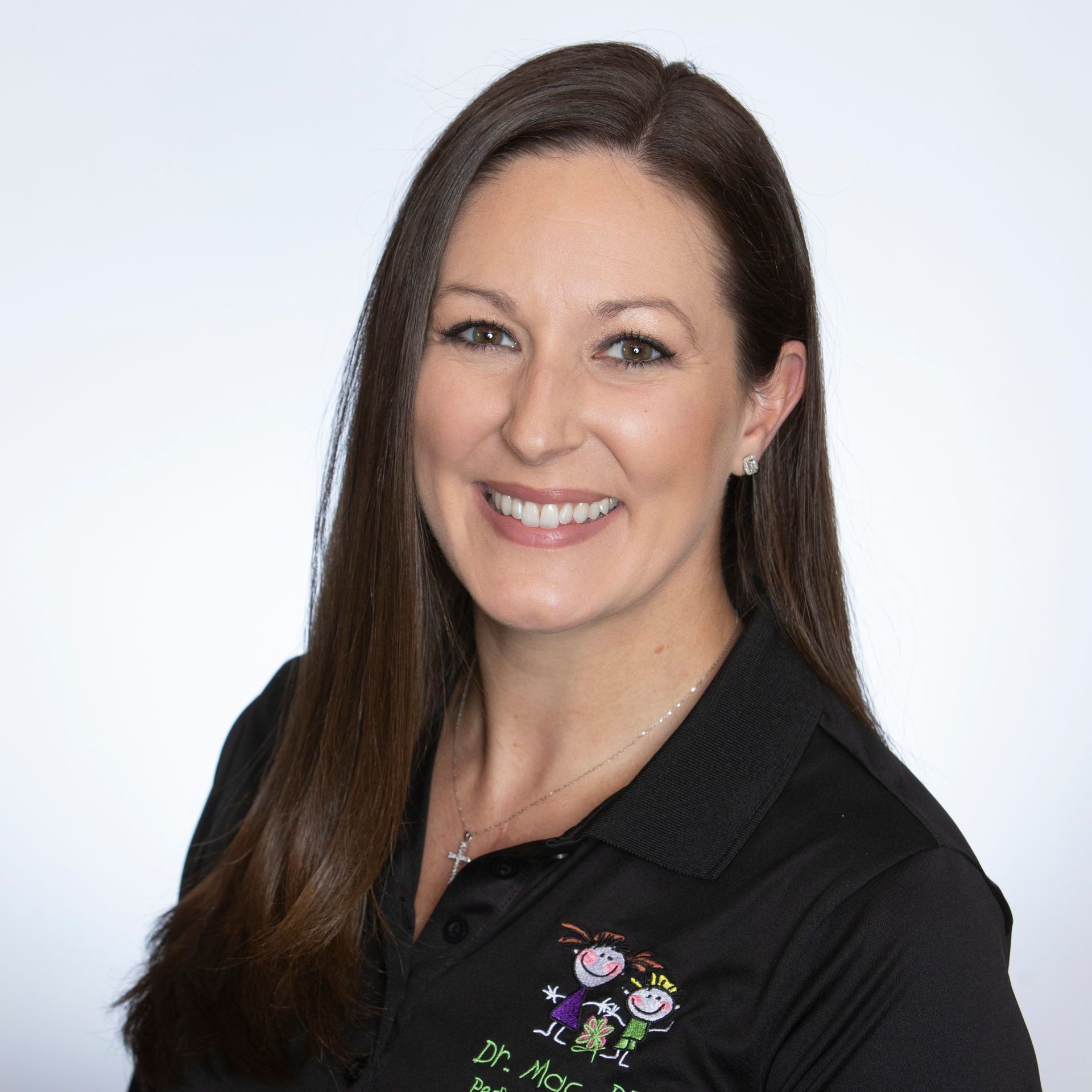 A woman wearing a black shirt with a picture of a child on it smiles for the camera.