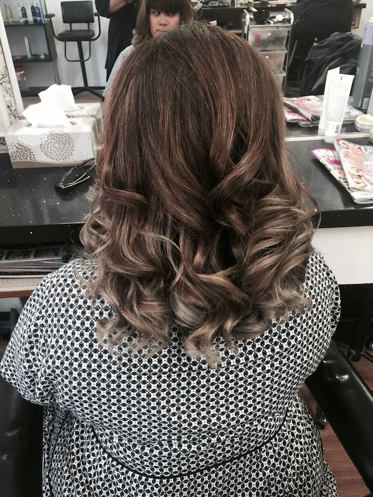 A Woman Is Getting Her Hair Done In A Salon — Howard Street Hair Studio In Nambour, QLD