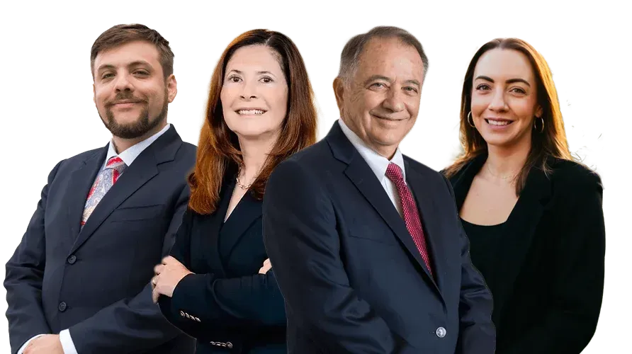 Four business professionals in dark suits standing together on a white background.