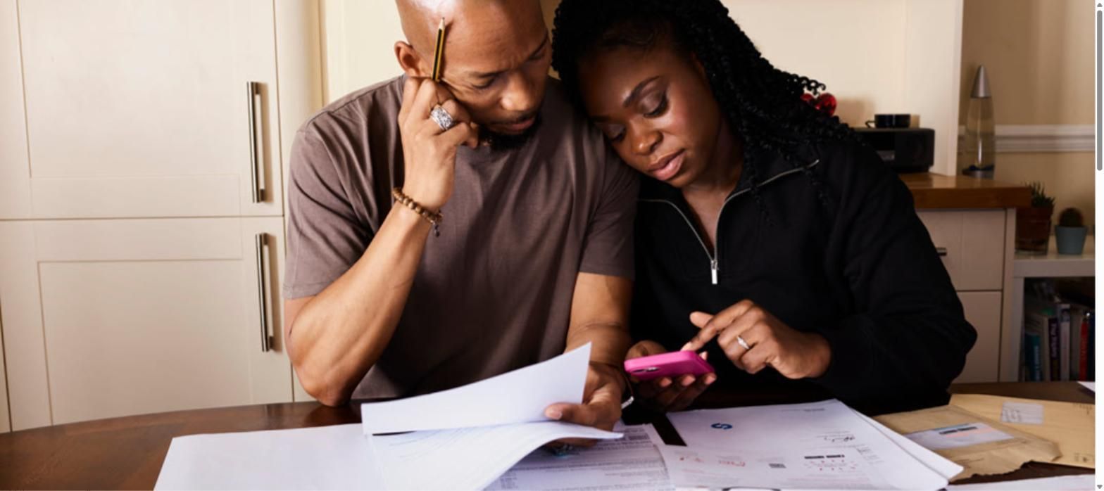 Couple reviewing health insurance paperwork and bills at their kitchen table