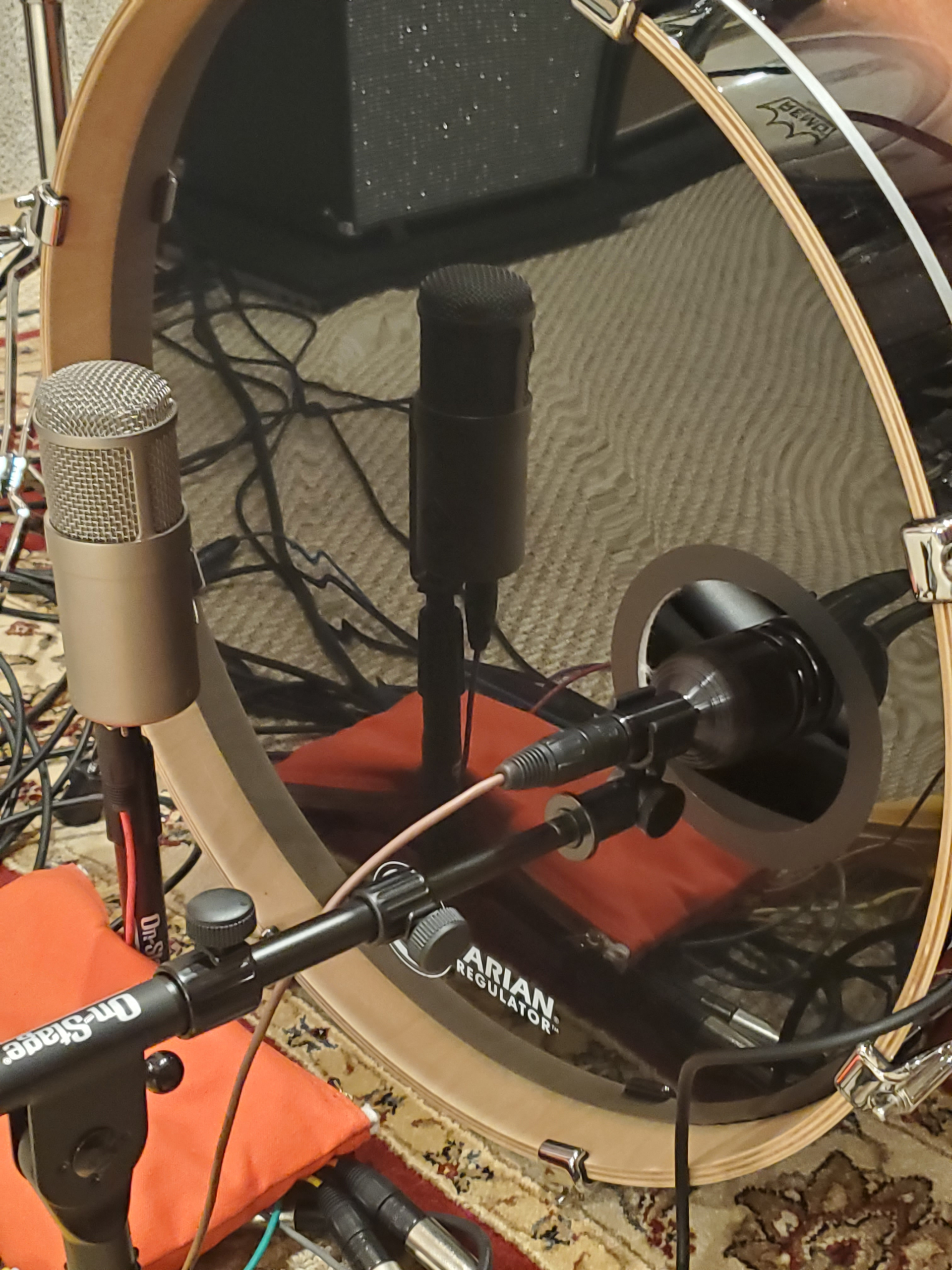 Three microphones are set up to record a bass drum, including one inside the drum shell and two positioned outside.